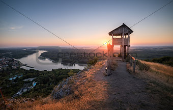 Wooden Tourist Observation Tower above a Little City with River 