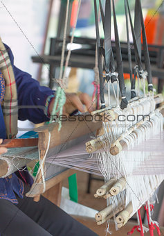 Woman weaving white pattern on loom