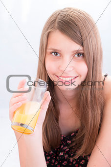 Smiling teenage girls drinking orange juice
