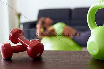 Home Fitness Red Weights On Table And Woman Training Abs