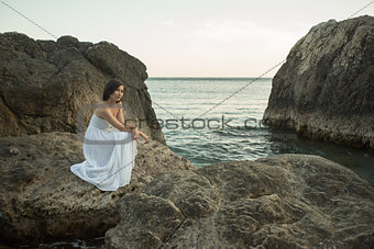 Beautiful woman sitting on a stone