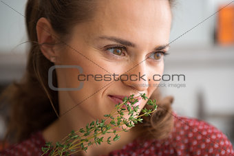 Closeup of woman smelling fresh thyme