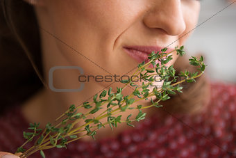Closeup of fresh thyme being smelled by an elegant woman