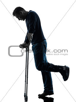 injured man walking sad with crutches silhouette