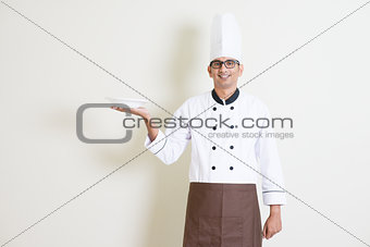 Indian male chef in uniform holding a plate