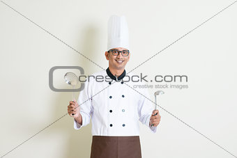 Indian male chef in uniform with kitchen tools