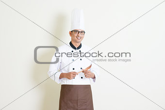 Indian male chef in uniform holding kitchen tool