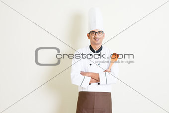 Indian male chef in uniform holding spatula