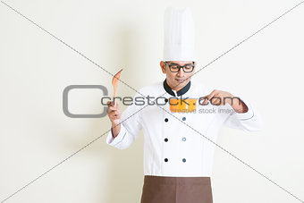 Indian male chef in uniform cooking and enjoy the food aroma