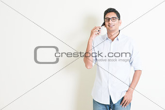Casual business Indian male talking on smartphone