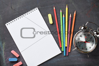 School supplies on blackboard background