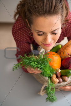 Woman with eyes closed smelling fresh fall vegetables