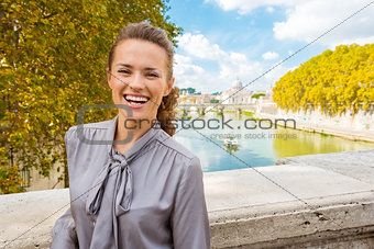Elegant, happy woman near Tiber River in Rome