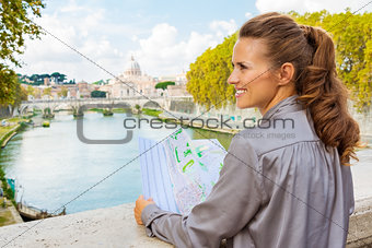 Profile of smiling woman holding map in Rome on Tiber River