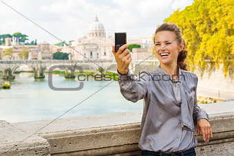 Smiling woman taking selfie in Rome by Tiber River