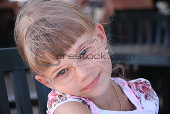 Smiling little blond girl with glasses
