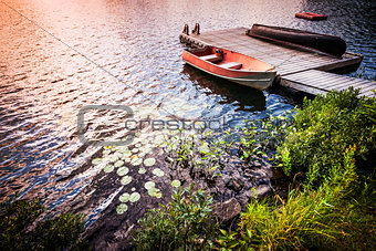 Rowboat at lake shore at sunrise