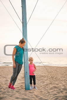 Mother and daughter in fitness gear standing by flagpole