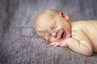 sleeper newborn baby on a gray background