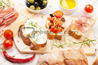 Bruschetta with cheese, tomatoes and prosciutto