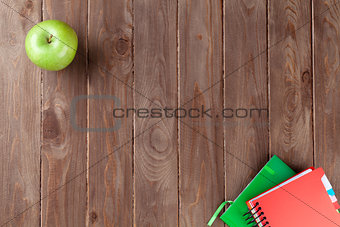 Notepads and apple on table