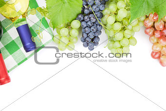 Bunch of red, purple and white grapes and wine bottles