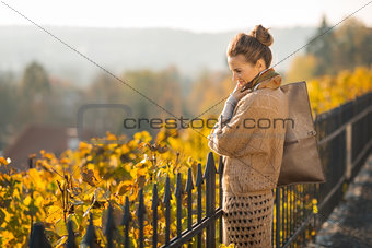 Portrait of smiling and looking down woman in autumn outdoors