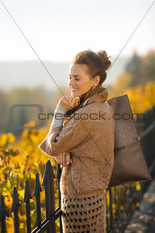 Portrait of happy elegant woman relaxing in autumn park