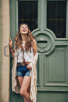 Happy young woman in boho clothes standing outdoors