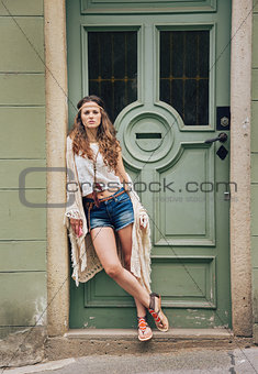 Pensive hippie woman in boho clothes standing outdoors