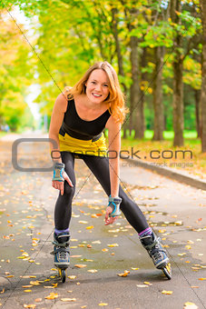 athlete posing on skates in the autumn deserted park