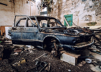 Old wrecked car inside of ruinous building