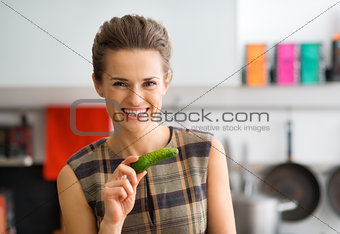Smiling woman holding fresh cucumber