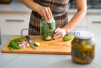 Closeup of woman's hands preparing cucumbers for dill pickles