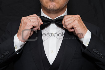 Gentleman in Black Tie Straightens His Bowtie