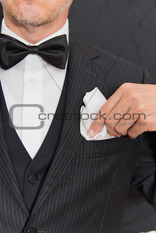 Gentleman In Black Tie Fixing Pocket Square, Vertical