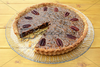 Pecan pie on a plate with one slice taken
