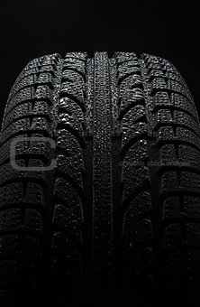 Tire with water drops over black background