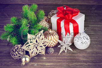 Christmas still life with fir gift and tinsel on wooden board