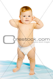 baby in diaper standing on a blue blanket. Studio. Isolated