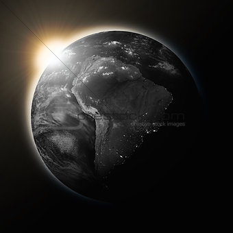 Sun over South America on dark planet Earth