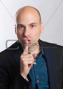 bald man with a gesture of shh