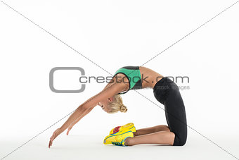 Rhythmic gymnast doing exercise in studio.
