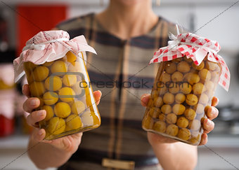 Closeup of yellow plums and gooseberries in glass jars