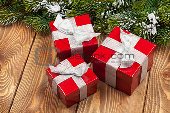 Christmas fir tree with snow and red gift boxes