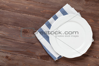 Empty plate over wooden table background