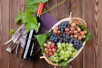Red wine bottle and colorful grapes