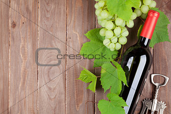 Bunch of grapes, red wine bottle and corkscrew