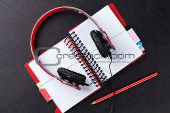 Headphones over notepad on desk