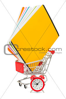 Shopping cart with copybooks and alarm clock